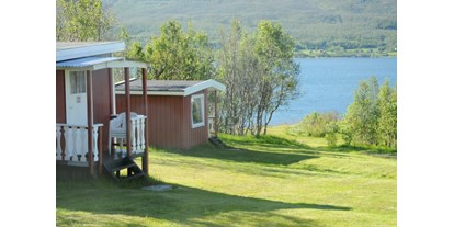 Motorhome parking space - Northern Norway - 10 small nostadiske hytter med 2-4 sengeplasser. Minikjøkken uten innlagt vann og avløp, derfor er servicebygget tilrettelagt med alt. Rett ved fjorden, midnattssola, naturbaserte opplevelser og minner for livet. - Sandnes Fjord Camping