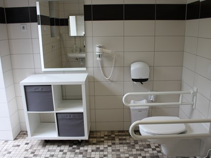 Reisemobilstellplatz - öffentliche Verkehrsmittel - Behindertentoilette und Dusche im Sanitärgebäude - Wohnmobilcamp See- und Waldresort Gröbern