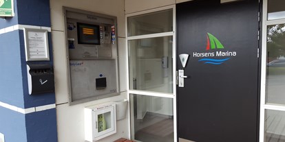 Motorhome parking space - Braedstrup - Ticketsutomat und Zugang zu einem sehr ordentlichen Sanitärgebäude mit kleinem Aufenthaltsraum und Küchenzeile - Stellplatz am Horsens Lystbådehavn