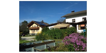 Reisemobilstellplatz - Umgebungsschwerpunkt: Fluss - Salzburg - Blick auf Hauptgebäude und modernen und sauberen Waschanlagen, die im gelben Haus mit Sonnenkollektoren zu sehen sind. - Camping Martina