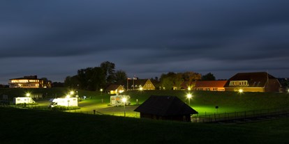 Reisemobilstellplatz - Art des Stellplatz: Sportstätte - Deutschland - Beleuchteter Stellplatz am Abend - Stellplatz am Elbdeich
