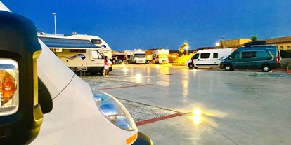Reisemobilstellplatz - Frischwasserversorgung - Italien - Der Stellplatz ist am Abend beleuchtet. - Area Sosta Porto San Paolo