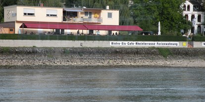 Reisemobilstellplatz - Hunsrück - Ansicht vom Rhein gesehen - Fasshotel am Rheinufer und Stellplatz am  Rheinkilometer 568