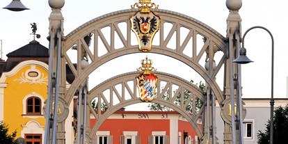 Reisemobilstellplatz - Traunstein (Landkreis Traunstein) - Länderbrücke mit Kaiserkrone und Wappen von Österreich, sowie Königskrone von Bayern mit dem Bayrischen Wappen - Fischer-Huber-Parkplatz