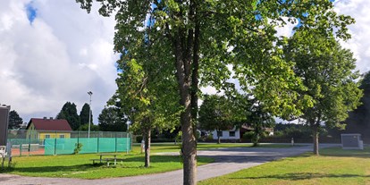 Reisemobilstellplatz - Umgebungsschwerpunkt: am Land - Niederösterreich - Mobilstellplatz Ottenschlag mit Blick zum Tennisplatz und Sitzgruppe. - Freizeitgelände Oberer Ortsteich