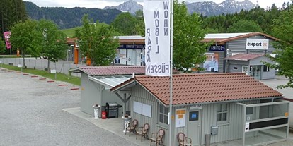 Reisemobilstellplatz - Weißenbach am Lech - Auf diesem Bild sehen Sie unser Rezeptionsgebäude mit den Sanitäranlagen dahinter. - Wohnmobilpark Füssen