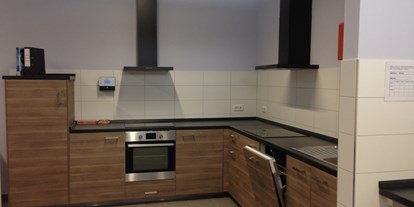 Reisemobilstellplatz - Gettorf - Die moderne und großzügig gestaltete Küche bietet auch Sitzgelegenheiten für insgesamt 8 Personen. - Wohnmobilstellplatz am Noor