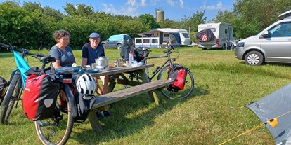 Reisemobilstellplatz - Duschen - Dänemark - Freunden mit den Fahrrad, Essen am Tisch  - Daler Camping