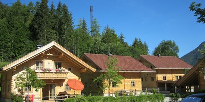 Reisemobilstellplatz - WLAN: teilweise vorhanden - Österreich - Holzblockhäuser im Areal des Campingplatzes - Karwendel Camping
