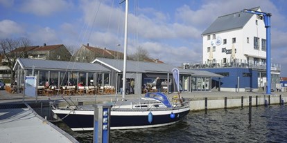 Reisemobilstellplatz - Art des Stellplatz: bei Freibad - Deutschland - Blick auf Eiscafé und maritimen Shop - Stellplatz am Schleswiger Stadthafen