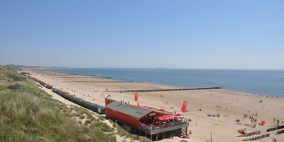 Reisemobilstellplatz - KAMPERLAND -  Strand hinter dem Campingplatzm mit Strandresaurant/bar Neptunes. - Camping Janse Zoutelande