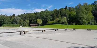 Motorhome parking space - Art des Stellplatz: Sportstätte - Oberbayern - Blick vom Platz aus auf den Festplatz, im Hintergrund Toilettenhaus - Berghalde Penzberg