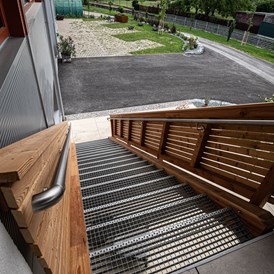 Wohnmobilstellplatz: Zugang Gästeterrasse - Blick auf Garten mit Stellplätzen - Gober & Freinbichler Weine von Hand