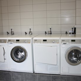 Wohnmobilstellplatz: Waschraum mit Waschmaschinen, Trockner und Bügelbrett - Wohnmobilcamp See- und Waldresort Gröbern