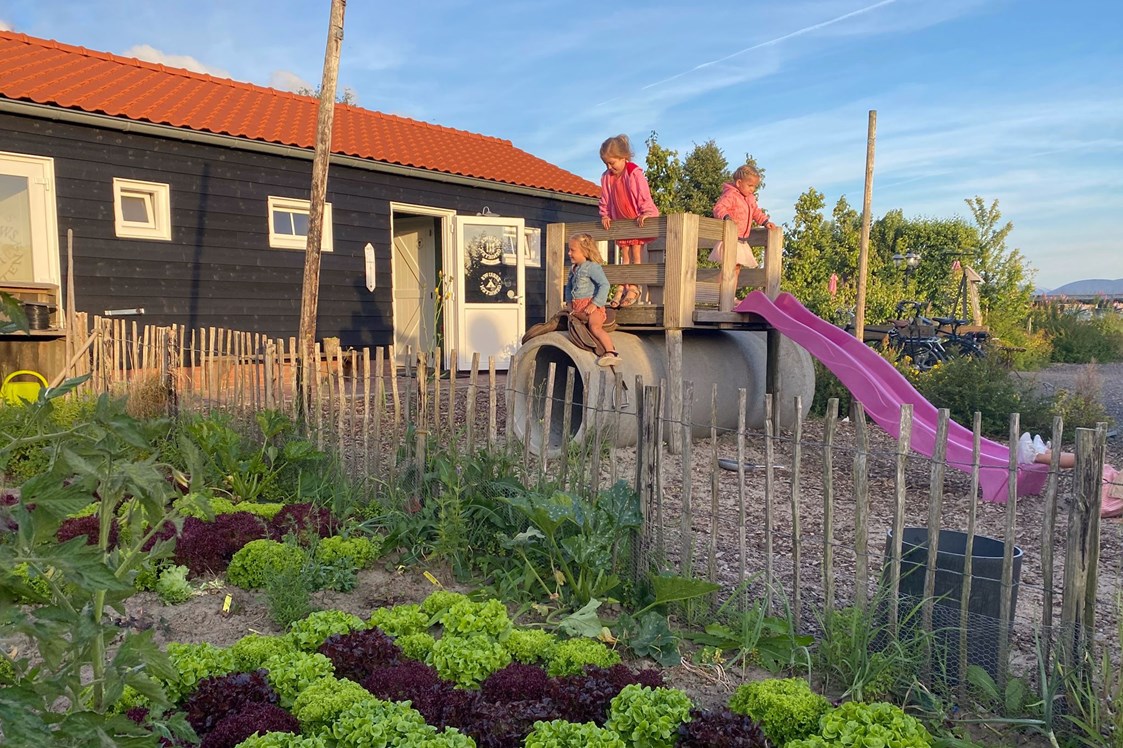Wohnmobilstellplatz: das Sanitärgebäude mit Gemüsegarten und kleinem Spielplatz - Camping Zeeuws Genieten
