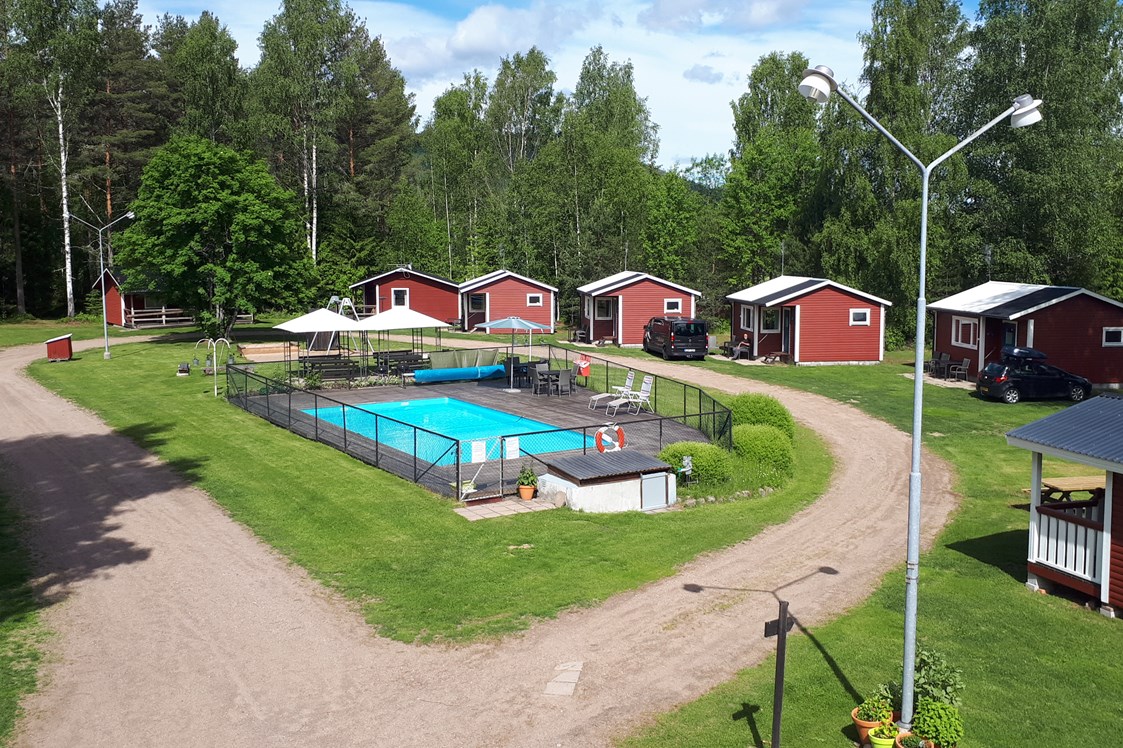 Wohnmobilstellplatz: Lager der Hütten und des Pools. Stellflächen befinden sich am linken Bildrand und rechts des Bildes. - Camping 45
