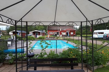 Wohnmobilstellplatz: Grillpavillon und der Pool.  Im Hintergrund das Servicegebäude. - Camping 45