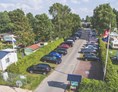 Wohnmobilstellplatz: Kostenloser Parkplatz und Einfahrt zum Campingplatz. vorn links eins unserer Miet Mobilheime. - Campingplatz Blauer See / Reisemobilstellplatz am Blauen See
