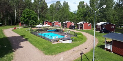Reisemobilstellplatz - Spielplatz - Schweden - Lager der Hütten und des Pools. Stellflächen befinden sich am linken Bildrand und rechts des Bildes. - Camping 45