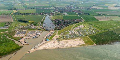 Reisemobilstellplatz - Nordseeküste - Luftaufnahme des Wohnmobilstellplatz und des Campingplatzes in Harlesiel. - Wohnmobilstellplatz an der Mole