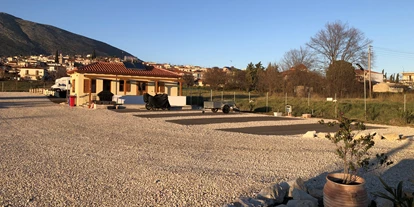 RV park - Grauwasserentsorgung - Peloponnese - Stellplätze mit Sanitäranlagen im Hintergrund  - Camperstop "Kalimera" 
