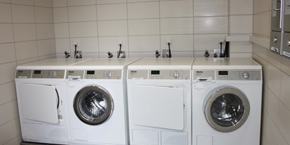Reisemobilstellplatz - Waschraum mit Waschmaschinen, Trockner und Bügelbrett - Wohnmobilcamp See- und Waldresort Gröbern