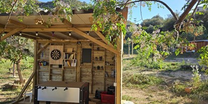 Motorhome parking space - WLAN: teilweise vorhanden - Sardinia - Gemeinschaftsbereich mit Sitzmöglichkeiten und Spielen - Piuma Campsite & More