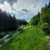 Parkeerplaats voor campers - meadow in village between mountains