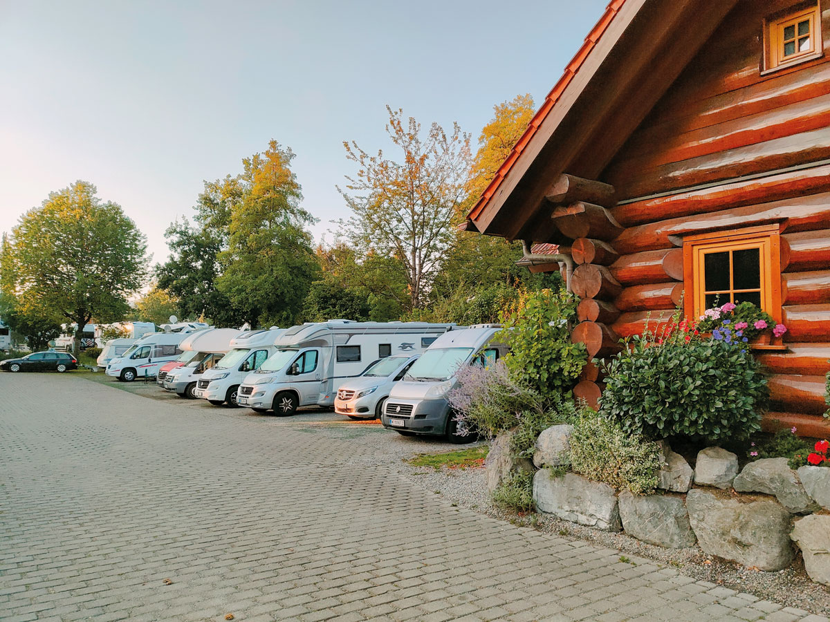 Wohnmobilstellplatz - Camper auf dem Übernachtungsstellplatz. Im Hintergrund ist das Rezeptionsgebäude des Campingparks Gitzenweiler Hof zu sehen. Die Plätze sind nicht buchbar. Sie können spontan anreisen. - Übernachtungsparkplatz vor dem Campingpark Gitzenweiler Hof (24/h)