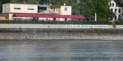 Reisemobilstellplatz - Sauna - Valwig - Ansicht vom Rhein gesehen - Fasshotel am Rheinufer und Stellplatz am  Rheinkilometer 568