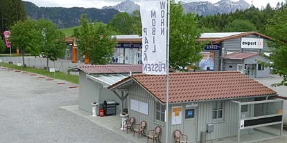 Parkeerplaats voor camper - Sulzberg (Landkreis Oberallgäu) - Auf diesem Bild sehen Sie unser Rezeptionsgebäude mit den Sanitäranlagen dahinter. - Wohnmobilpark Füssen