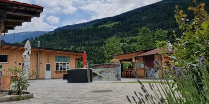 Motorhome parking space - Stromanschluss - Am Putzenhof - Eingangsbereich, Treffpunkt Rafting, Outdoor Bar im Hintergrund - Adventurepark Osttirol