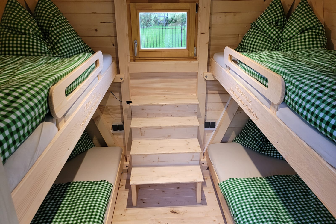 Wohnmobilstellplatz: 50 Holz-Chalets mit jeweils 4 Betten (Stockbetten) bieten eine gemütliches Glampingerlebnis für Gäste, die ohne Zelt anreisen möchten.  - Schitterhof CAMPING WEISS