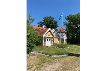 Wohnmobilstellplatz: Wohnhaus mit gehisster schwedischer Flagge - Einzel-Wohnmobilstellplatz auf Halbinsel Knösö