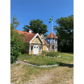 Wohnmobilstellplatz: Wohnhaus mit gehisster schwedischer Flagge - Einzel-Wohnmobilstellplatz auf Halbinsel Knösö