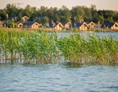 Wohnmobilstellplatz: Blick über den Gröberner See auf die Ferienhäuser des See- und Waldresorts Gröbern - Wohnmobilcamp See- und Waldresort Gröbern