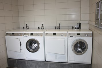 Wohnmobilstellplatz: Waschraum mit Waschmaschinen, Trockner und Bügelbrett - Wohnmobilcamp See- und Waldresort Gröbern