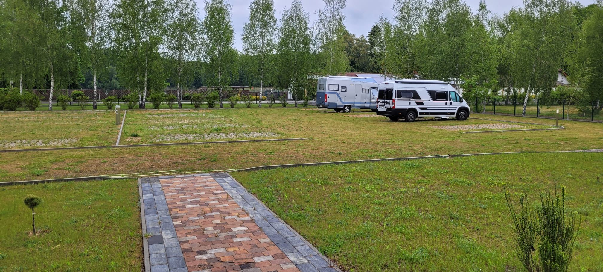 Area sosta per camper - Eisenhüttenstadt - Blick vom Sanitärgebäude auf Stellplatz, dahinter See & Restaurant - Stellplatz am Katharinensee