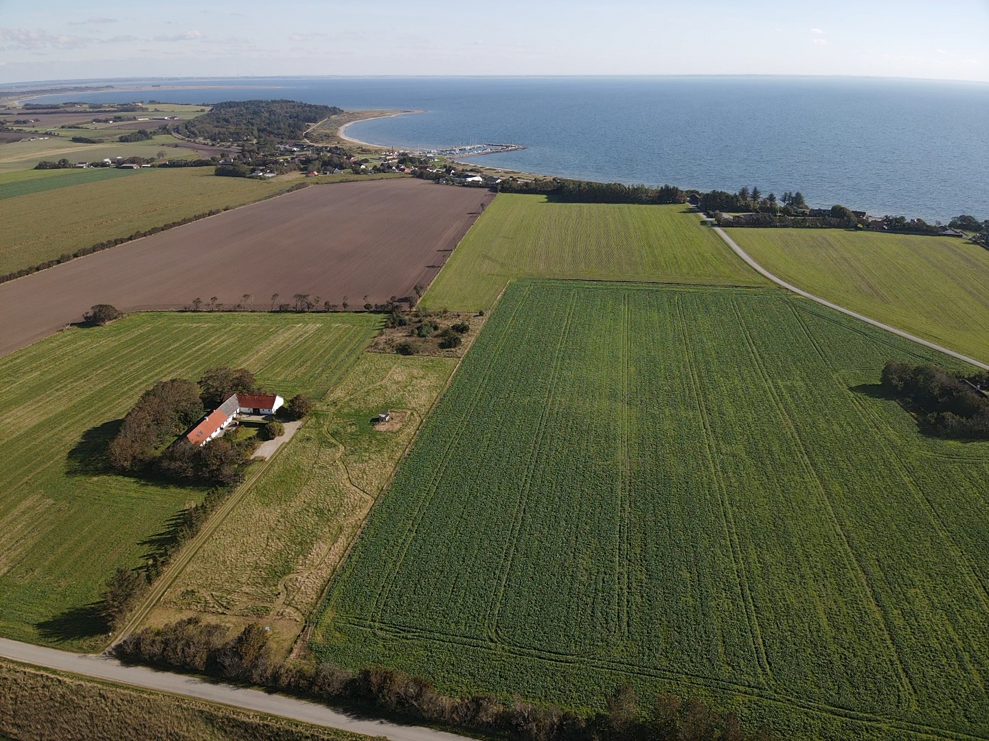 Reisemobilstellplatz - Erslev - Im Vordergrund hinter der Hecke sind die beiden Stellplätze und im Hintergrund ist Amtoft und der Limfjord zu sehen. - Vesløs mit Blick auf See und Naturschutzgebiet