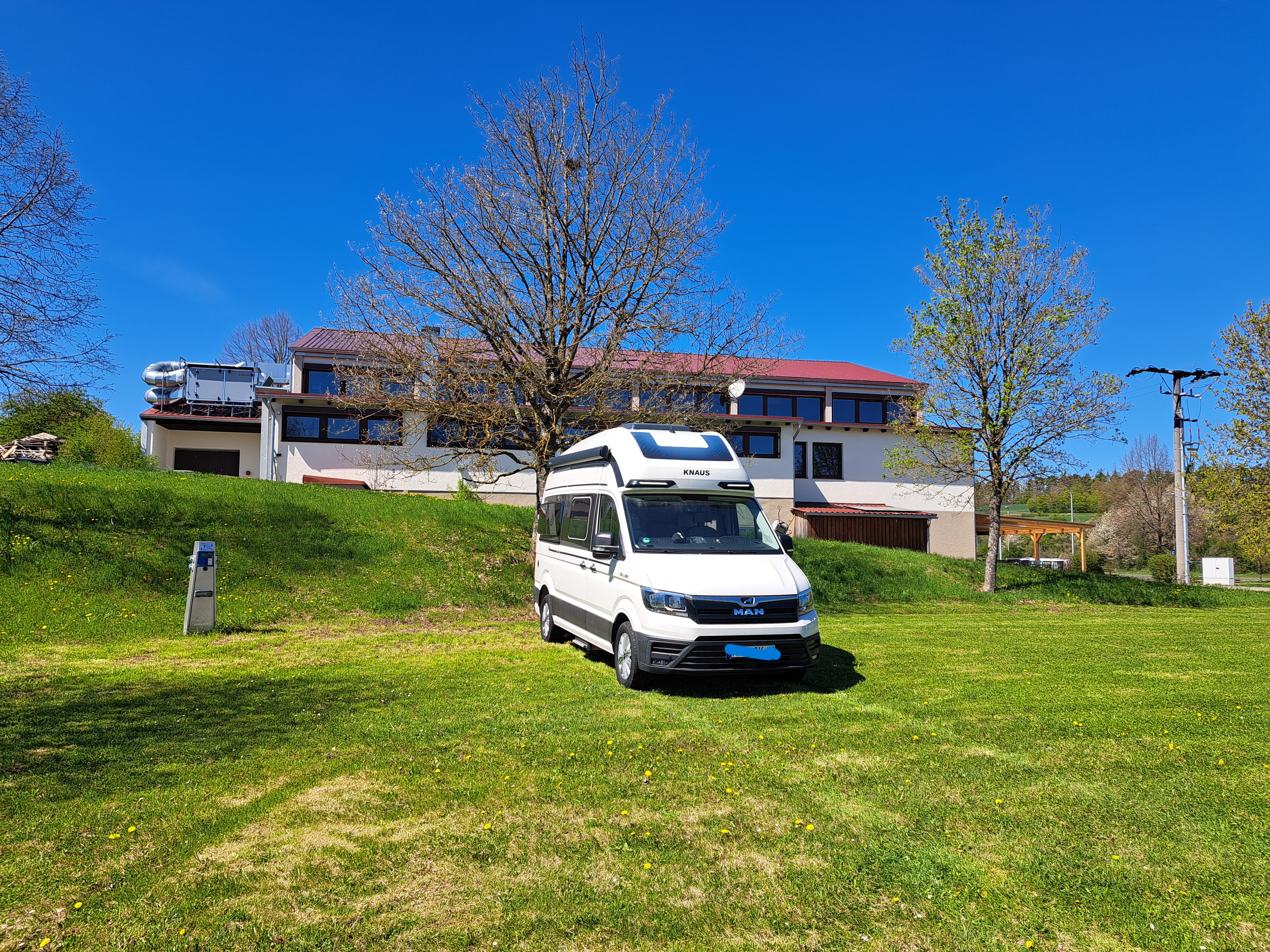 Wohnmobilstellplatz: Stellplatz 1 im Hintergrund Sportheim - Zimmermannsplatz