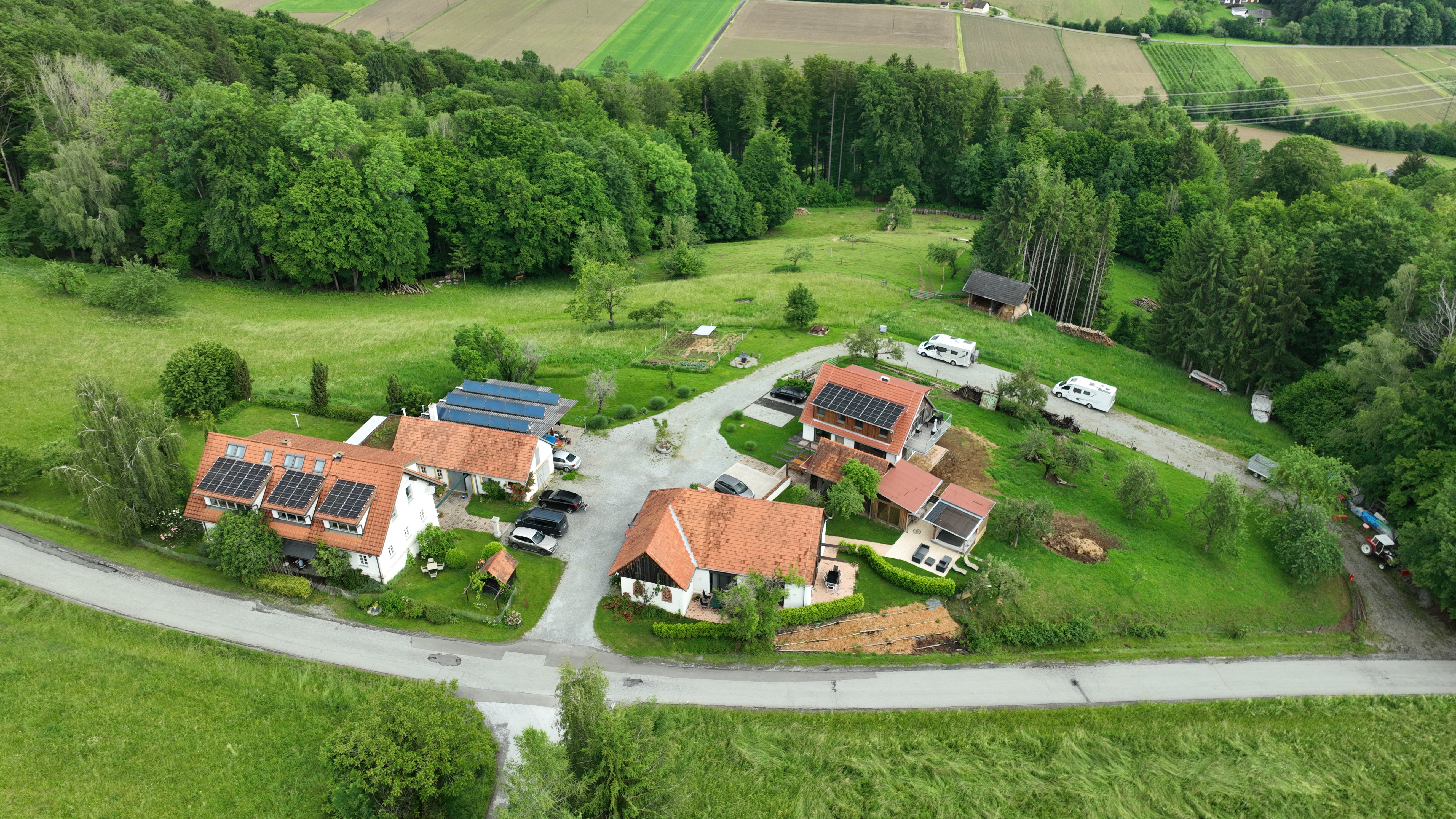 Area sosta per camper - Thermenland Steiermark - Vogelperspektive auf die Wohlfühloase am Trausdorfberg: nachhaltiger Bauernhof mit Photovoltaik, eingebettet in Wiesen und Wald. Wohnmobilstellplatz im unteren Bereich. Südoststeiermark – 20 Min. von Graz. wohlfuehloase.com - Wohlfuehloase am Trausdorfberg