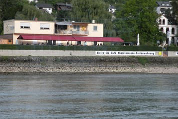 Wohnmobilstellplatz: Ansicht vom Rhein gesehen - Fasshotel am Rheinufer und Stellplatz am  Rheinkilometer 568