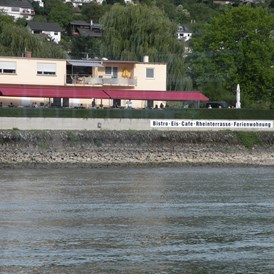 Wohnmobilstellplatz: Ansicht vom Rhein gesehen - Fasshotel am Rheinufer und Stellplatz am  Rheinkilometer 568