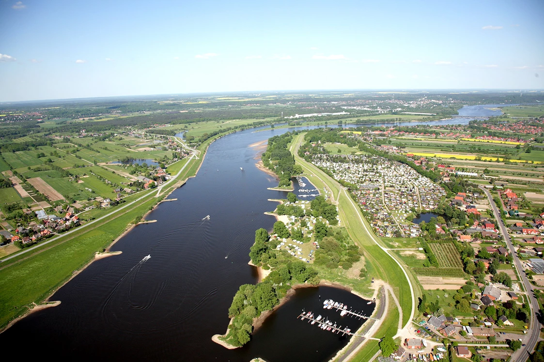 Wohnmobilstellplatz: Der Blick aus der Luft auf die Elbe und den Wohnmobilpark Camping Stover Strand mit seinem Bootshafen. - Wohnmobilpark Stover Strand bei Hamburg an der Elbe