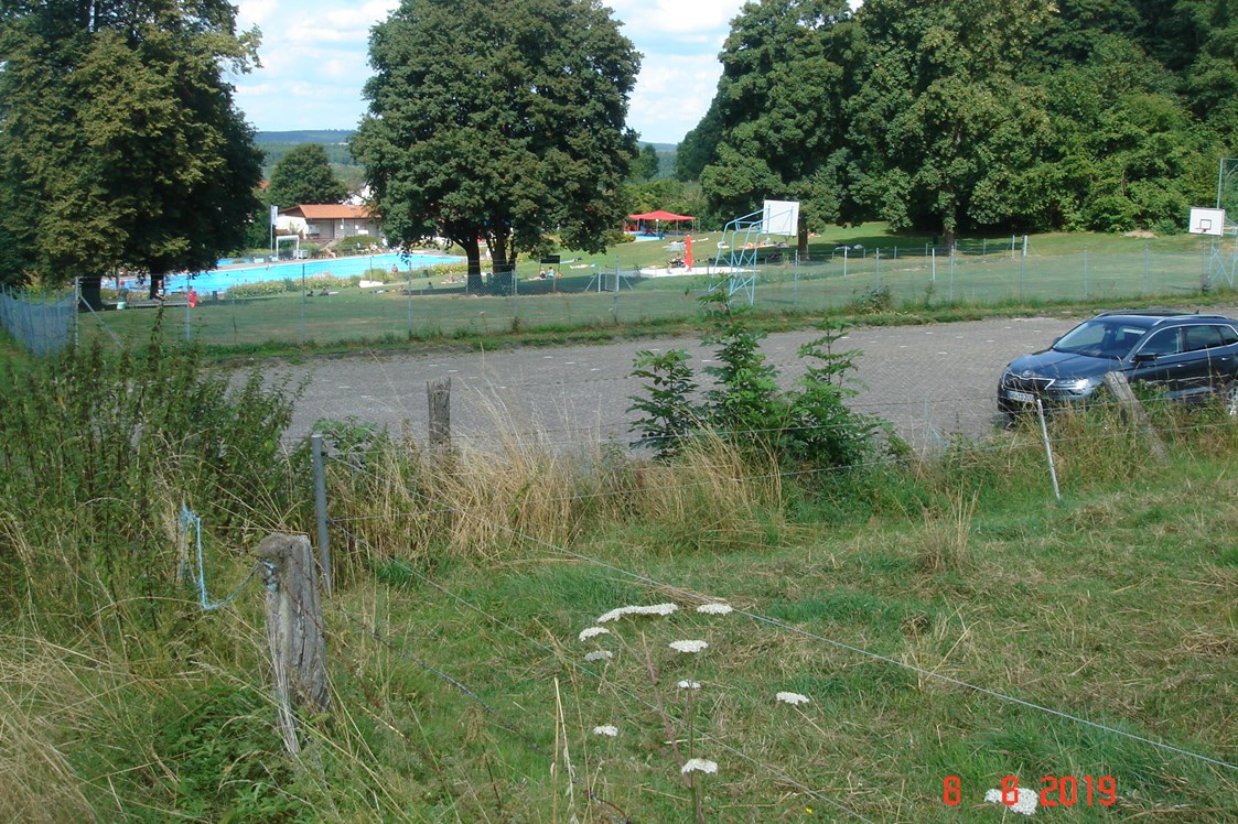 Wohnmobilstellplatz: Blick auf das Ratburgbad und dem Parkplatz im Vordergrund - Parkplatz Ratsburgbad 37120 Bovenden