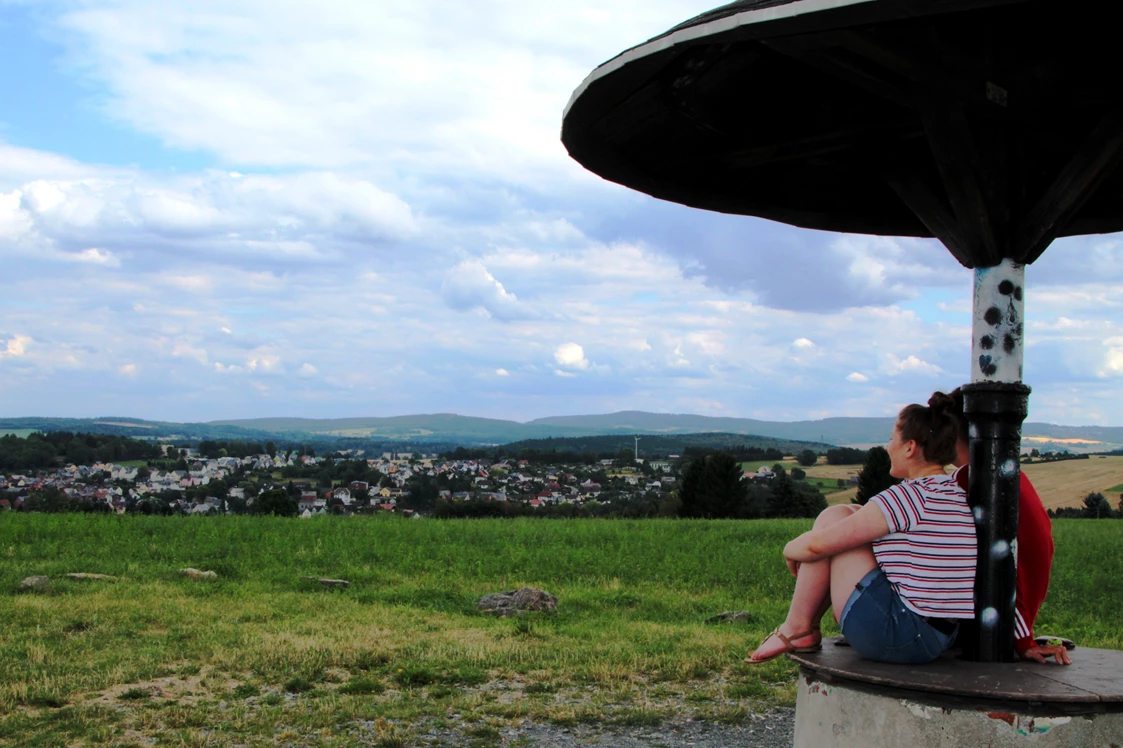 Wohnmobilstellplatz: Richtung Osten türmen sich vom Aussichtspunkt "Pilz" aus die Höhenzüge des Erzgebirges auf. Die Kleinstadt Lengenfeld mit ihren rund 5000 Einwohnern liegt dem Betrachter sozusagen zu Füßen. Frühaufsteher können oft einen beeindruckenden Sonnenaufgang verfolgen.  - Naturhof Vogtland