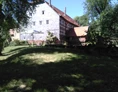 Wohnmobilstellplatz: Blick auf die Mühle und das Staubecken. Der obere Teil der Wiese ist sehr schattig den ganzen Tag über (nicht befahrbar, nur Liegewiese od. Campingwiese) - Brücker Mühle