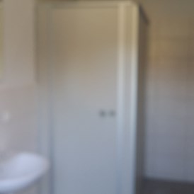 Wohnmobilstellplatz: Wir verfügen über ein Sanitärgebäude - mit WCs, Duschen sowie Einzelwaschplätzen - getrennt nach Geschlechtern. Ebenso Grauwasserentsorgung über Bodenablaufrinne, Schüttloch für Fäkalkassettenentleerung, Trink- und Brauchwasserversorgung. - Pension Yvonne Sigg - Caravan Island