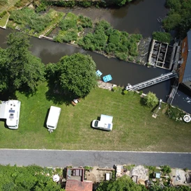 Wohnmobilstellplatz: Luftbild mit den Wohnmobil Stellplätzen (links und Mitte), Parkplätzen für die Autos (rechts) und der Wesenitz - Wohnmobilstellplatz Hofemühle 6x12m Nr. 06