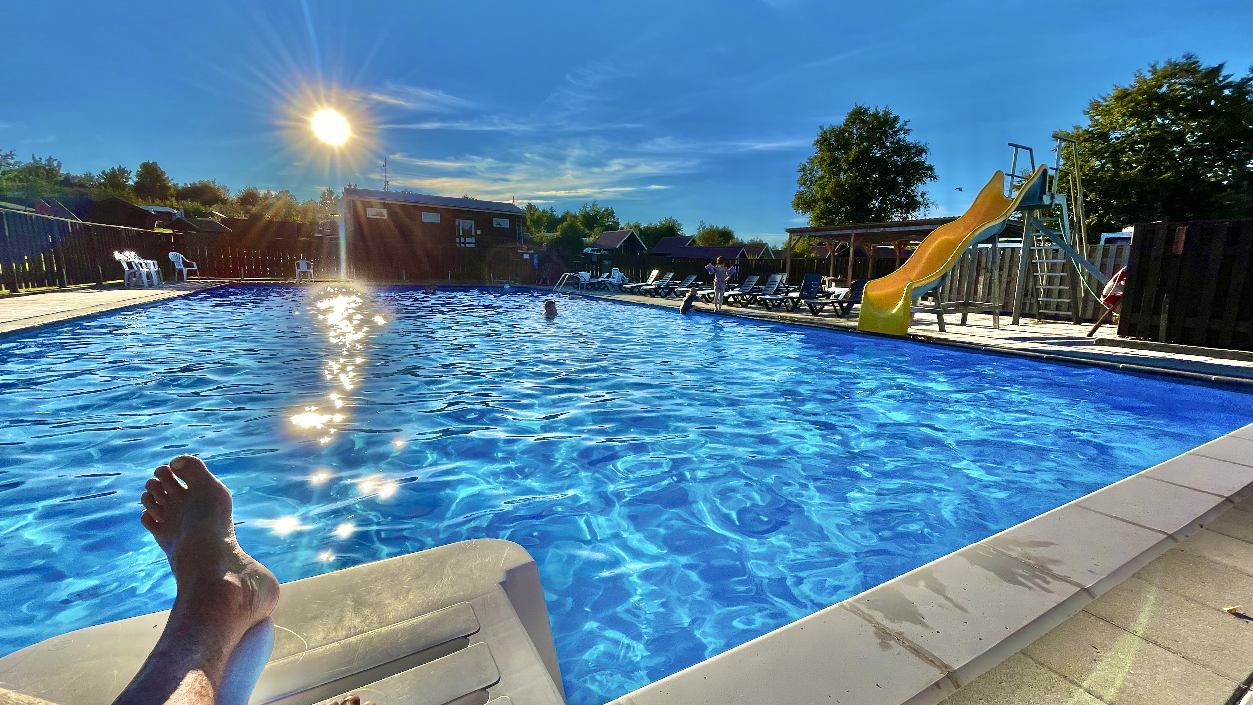 Wohnmobilstellplatz: Heated outdoor pool in the sunny weather at Hjarbæk Fjord Camping in Central Jutland.  - Hjarbæk Fjord Camping